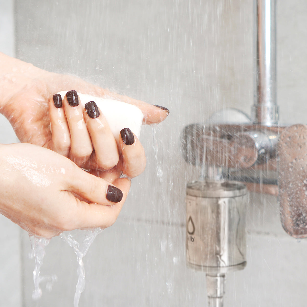 Hände mit Seife unter der Dusche, im Hintergrund der Alb Duschfilter an der Armatur