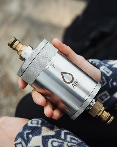 Person hält ein Alb Filter Edelstahlgehäuse mit Anschlussfitting in der Hand