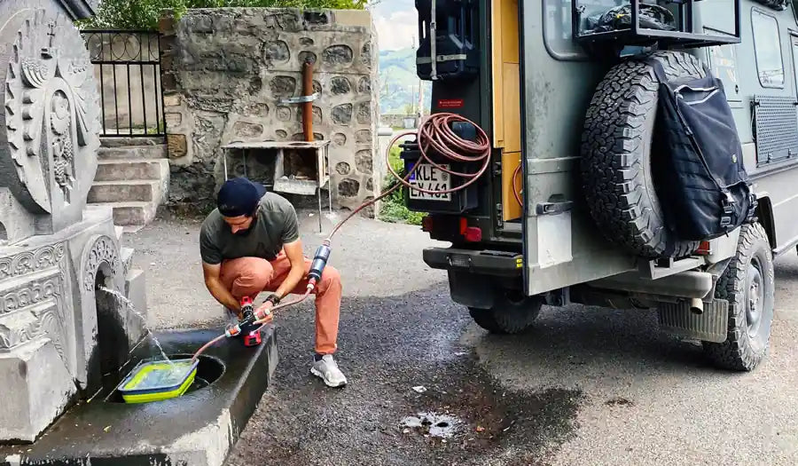 Improvisierte Wasserentnahme im Ausland mit einer Bohrmaschinenpumpe: eine von mehreren Quellen für Trinkwasser, deren Qualität niemand nachweisen muss.