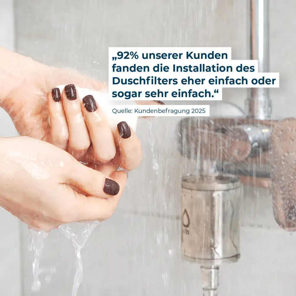 Im Vordergrund Hände mit Seife, im Hintergrund der Alb Duschfilter an Duscharmatur