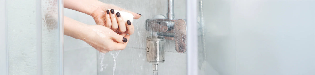 Frau seift sich unter der Dusche mit dem Alb Filter Element Duschfilter ein