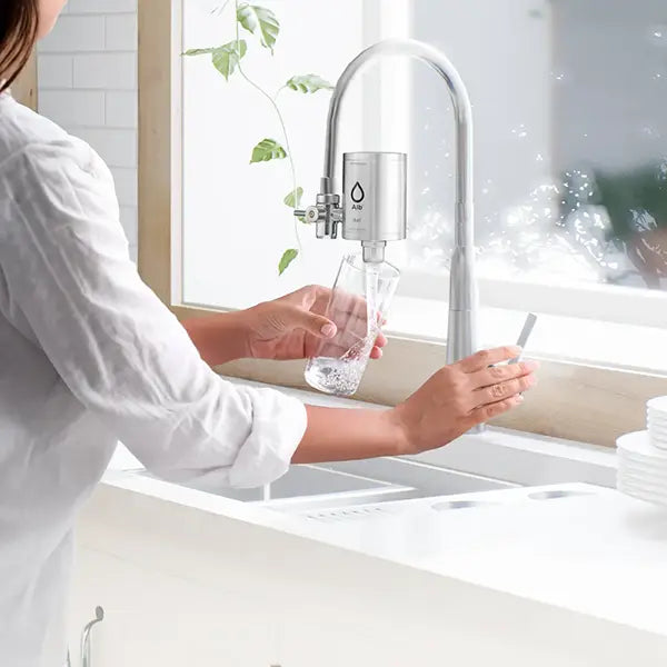 Frau nutzt den Alb Filter Duo für frisches Trinkwasser direkt am Hahn.