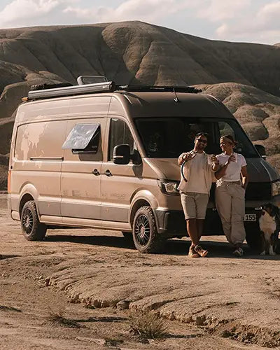Ehepaar mit Hund vor ihrem Camper-Van in einer Wüstenlandschaft – Alb Filter Community-Foto