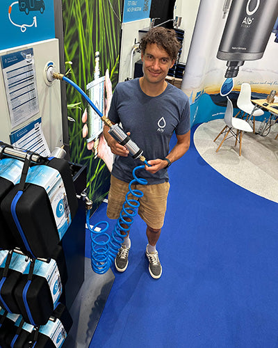 Mann präsentiert den Alb Filter Mobil mit Flextube-Schlauch auf einer Messe