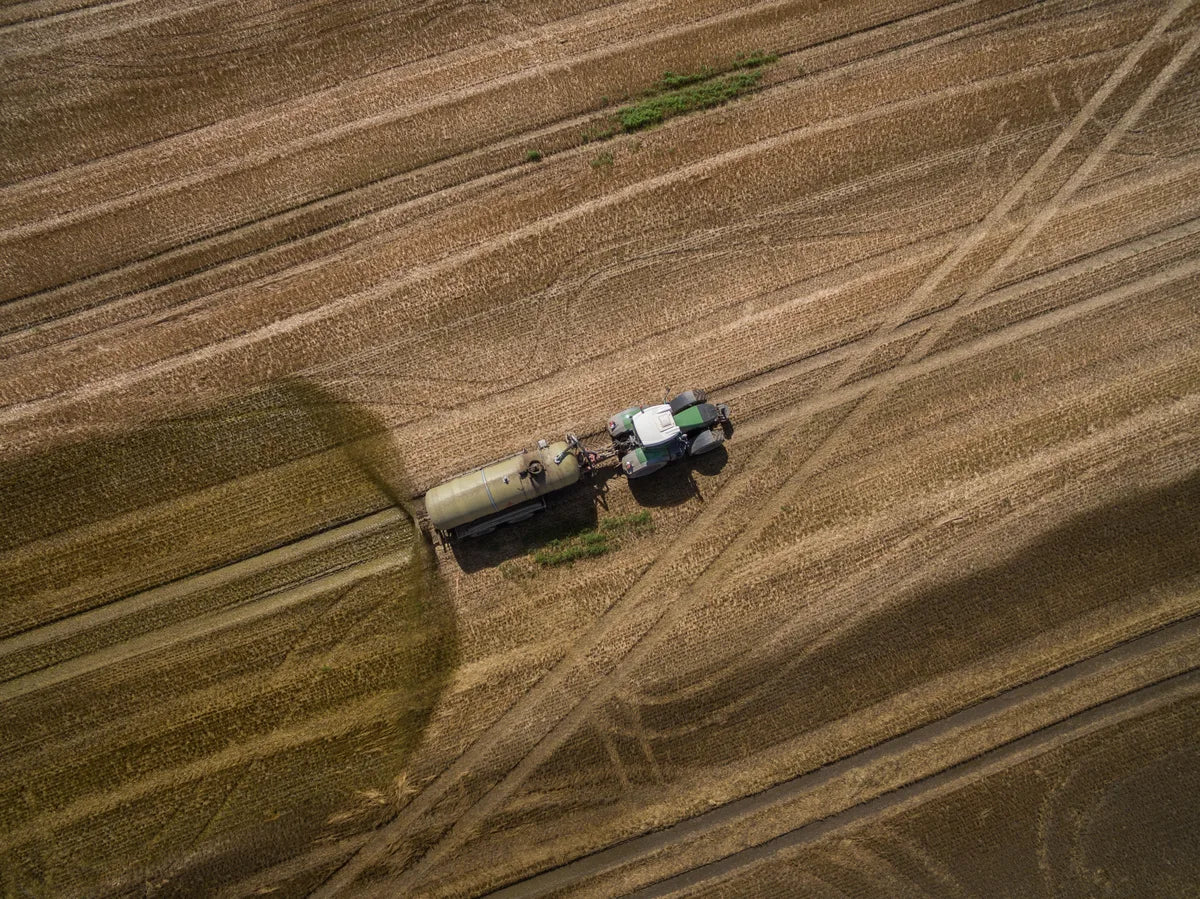 Traktor bringt Gülle auf einem Feld aus