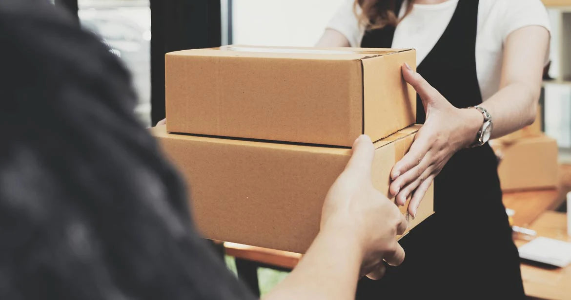 Paketbote übergibt ein Paket – Sinnbild für die versandkostenfreie Lieferung der Alb Filter Kartuschen im Spar-Abo.