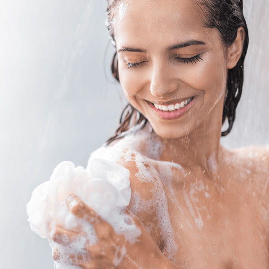 Frau duscht mit Alb Filter Duschfilter unter der Dusche