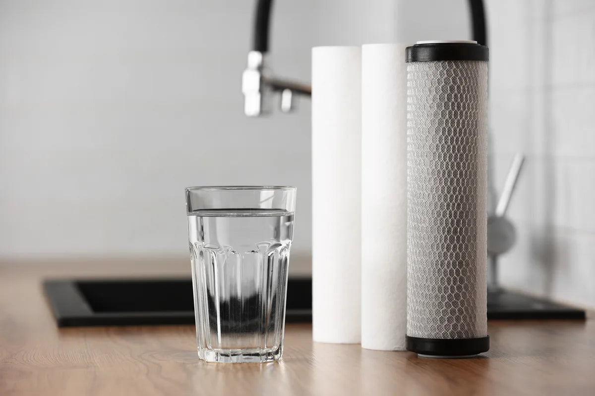 Wasserglas mit Filterkartuschen auf Küchentisch